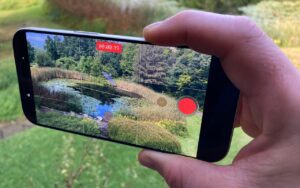 iPhone held horizontally while shooting a video to illustrate Take Quick Videos with the Camera Control | AustinMacWorks.com